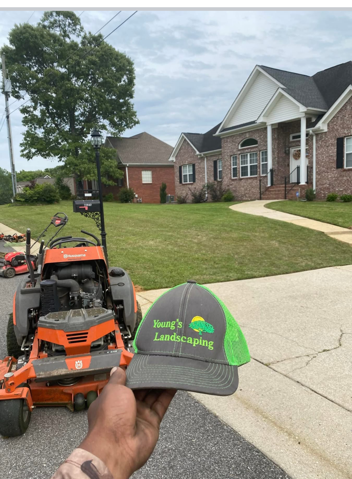 Young's Landscaping hat with Husqvarna stand-on mower
